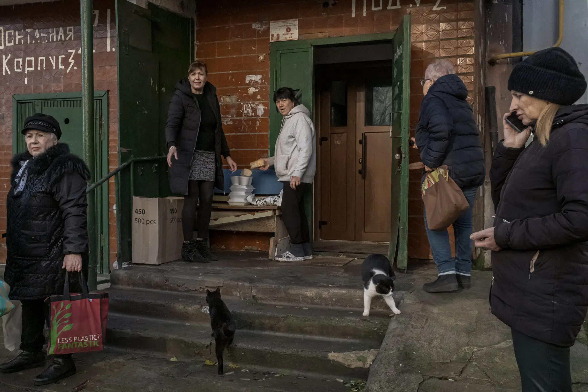 Мешканці збираються біля своїх квартир, щоб отримати їжу від Peaceful Heaven у житловому кварталі Херсона. Починаючи з червня, група щодня доставляла жителям міста 2500 страв і 500 буханок хліба.
